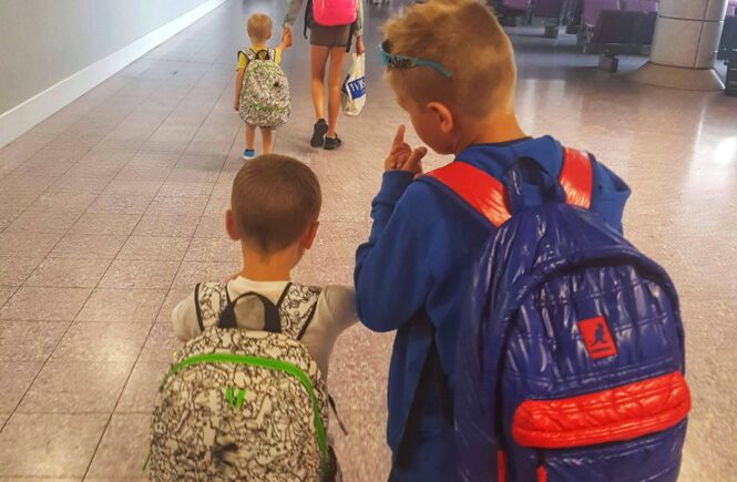 four children walking through an airport
